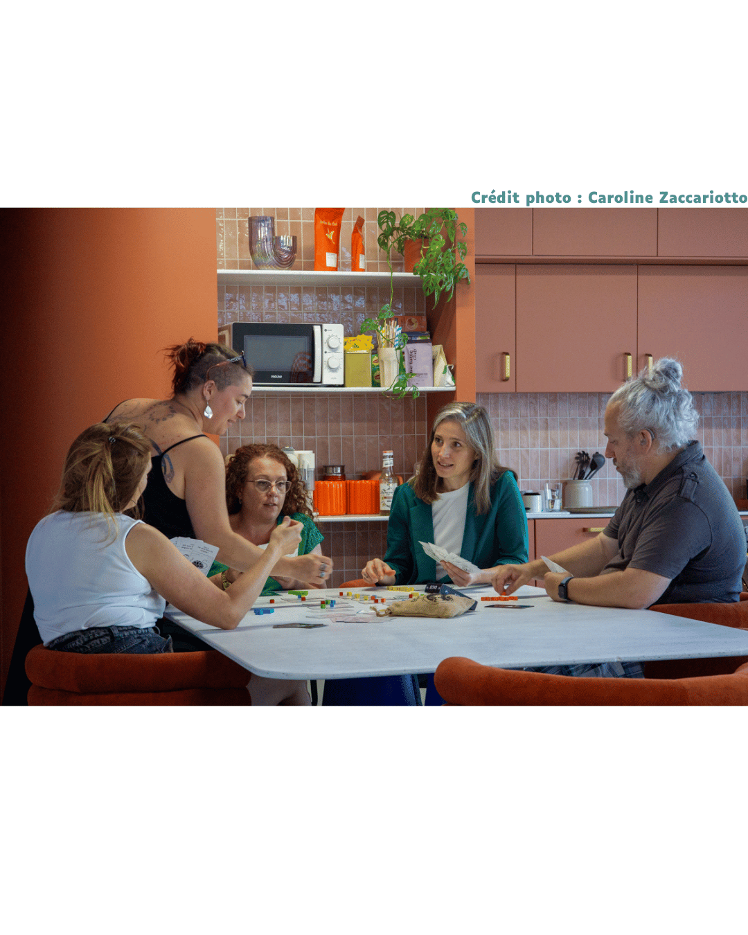 4 personnes sont assises autour d'une table, le jeu Echo est disposé sur la table. La formatrice est en train d'expliquer une règle.